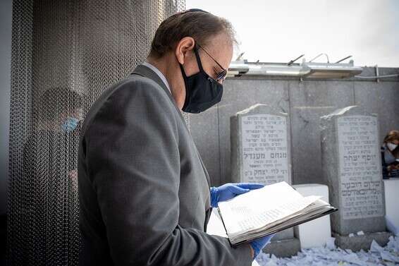 מניח תפילין ליד קברו של הרבי מלובביץ' // צילום: שחר עזרן